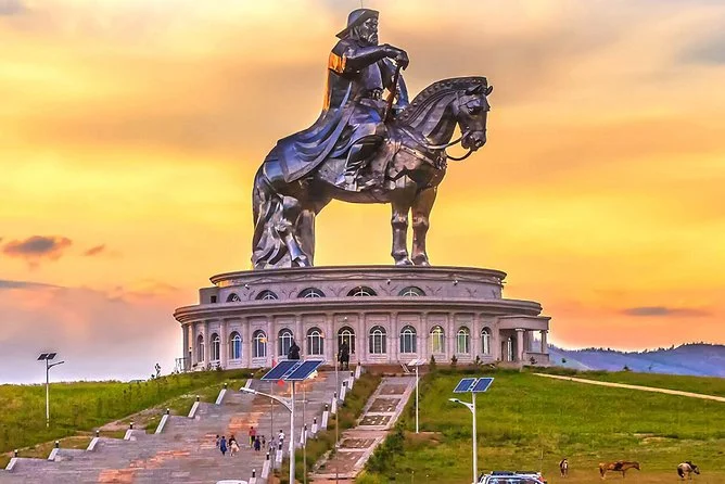 Estátua monumental de Gêngis Khan montado a cavalo na Mongólia ao pôr do sol, representando o legado do Império Mongol.
