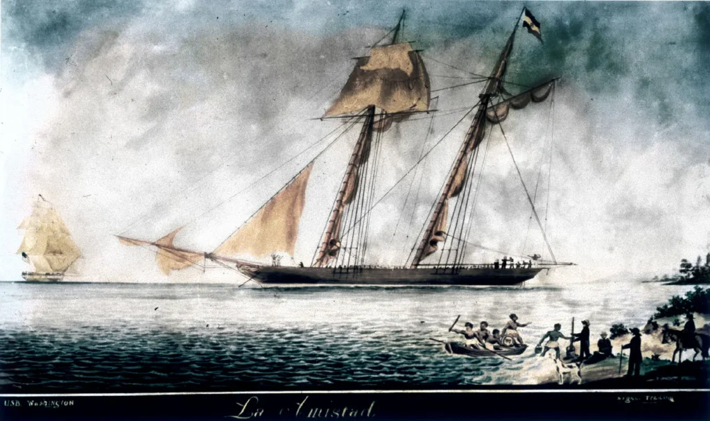 Ilustração histórica do navio La Amistad, embarcação associada à revolta de africanos escravizados em 1839, próximo à costa, com pequenas embarcações e pessoas em primeiro plano.
